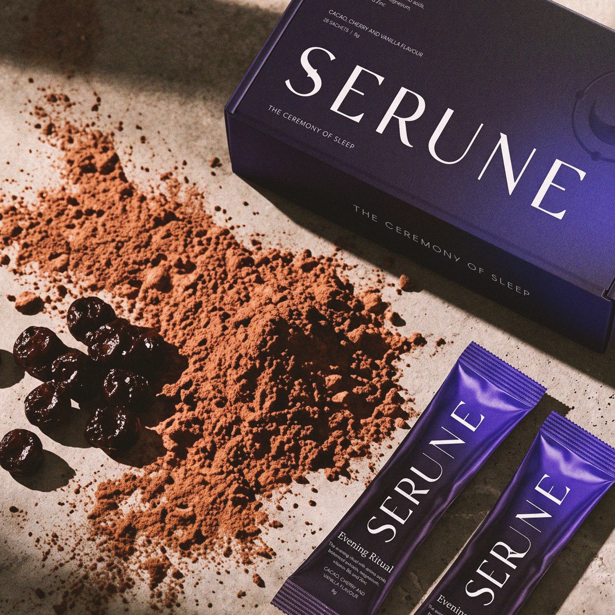 The Serune box and two sachets laid out with cacao powder and dried cherries