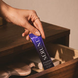 A hand taking a Serune sachet from a bedside drawer